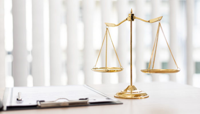 Law paperwork and scales on a desk.