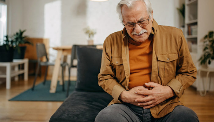 Older senior man holding stomach with gut vitality
