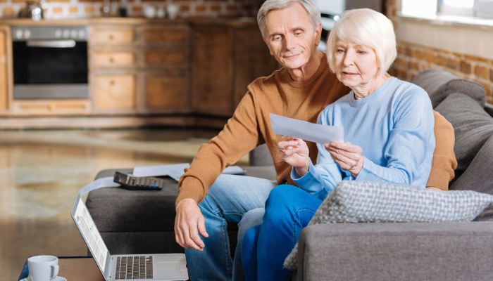 Older couple on couch reviewing social security benefits