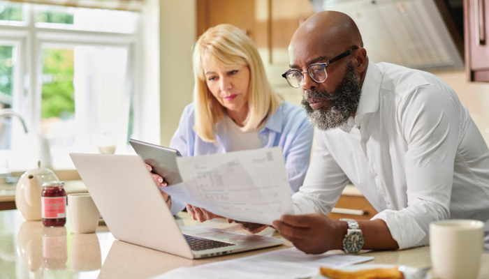 Interracial couple looking at essential legal documents for every senior