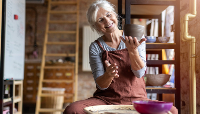 Woman admiring the timeless art of pottery she made