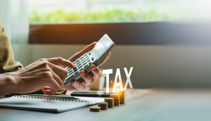 Woman using calculator working on taxes.