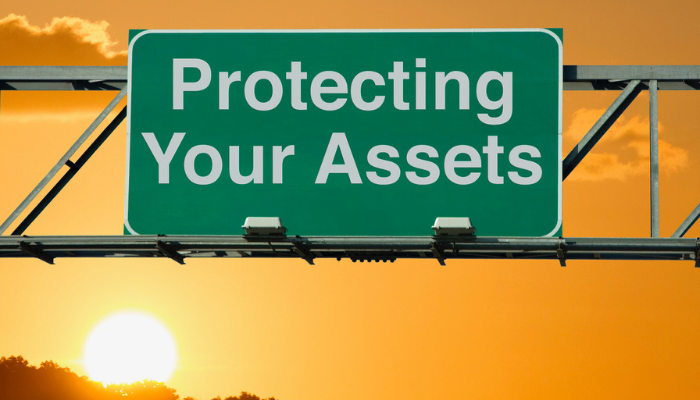 Interstate sign showing protecting your assets during sunset.