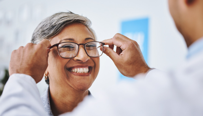 Older woman trying on eyeglasses.