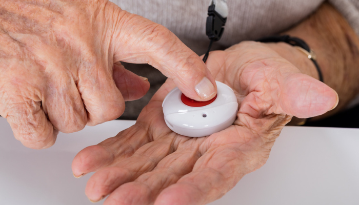Woman's hand pushing a medical alert button.