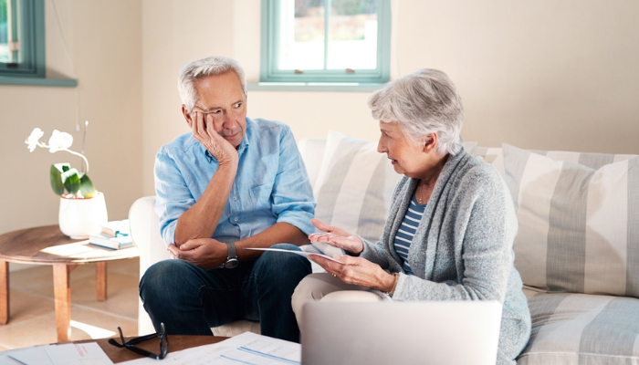 Older couple talking on couch.