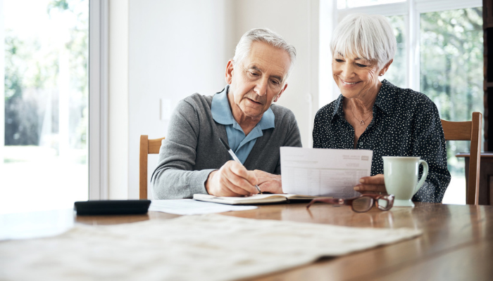 Senior couple sitting at table discussing Medicare paperwork.