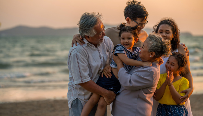 Happy Hispanic family with grandparents, grandchildren and children on a beach.