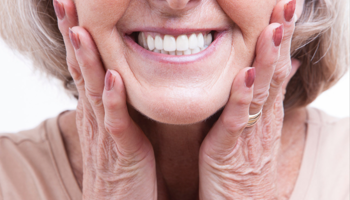Senior woman smiling showing her teeth for Medicare Dentures.