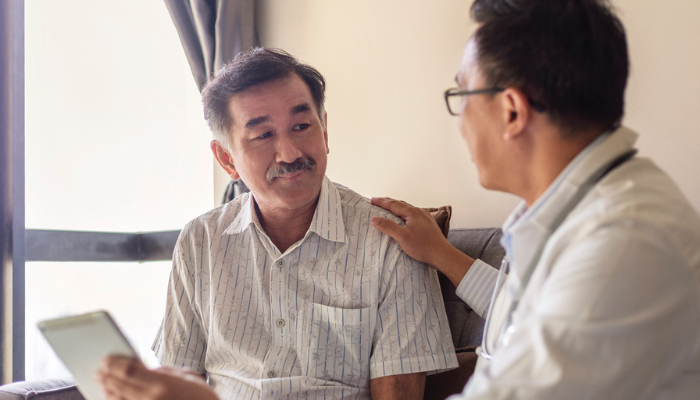 Older Asian man speaking to his doctor.