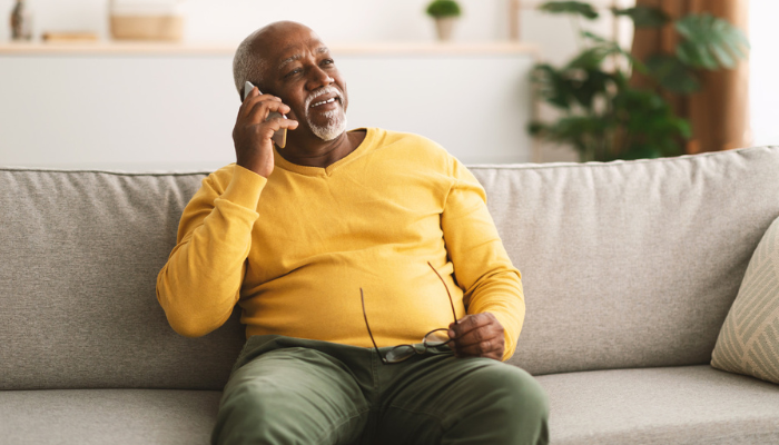 Senior African American man on the phone with Medicare at home.