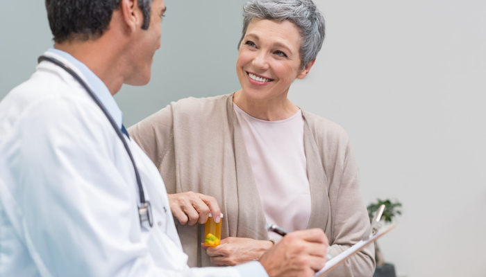Senior woman smiling talking to doctor.