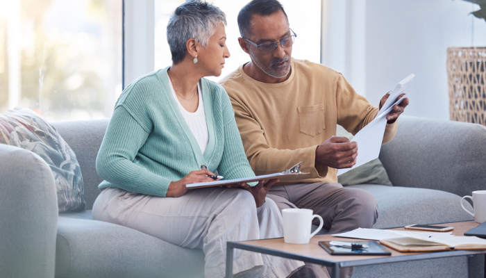 Senior couple discussing Medicare plans on couch together.