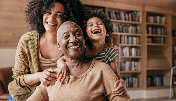 Three generations of happy African American women laughing.