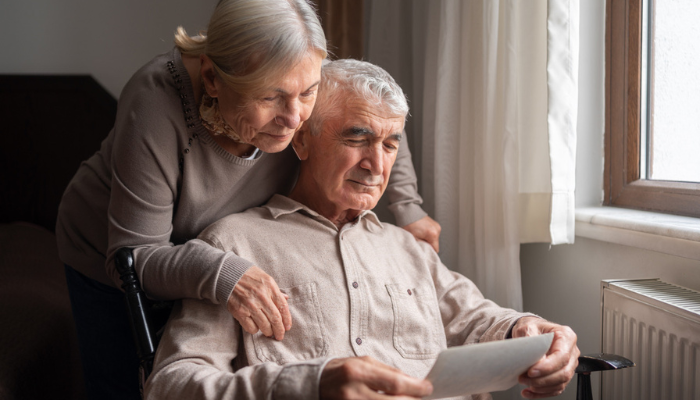 Older couple reading paperwork together at home.